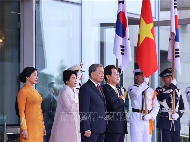 Tổng thống Hàn Quốc Lee Jae Myung và Phu nhân cùng Tổng Bí thư Tô Lâm và Phu nhân tại vị trí danh dự, nghe quân nhạc cử Quốc thiều hai nước. Ảnh: Thống Nhất - TTXVN