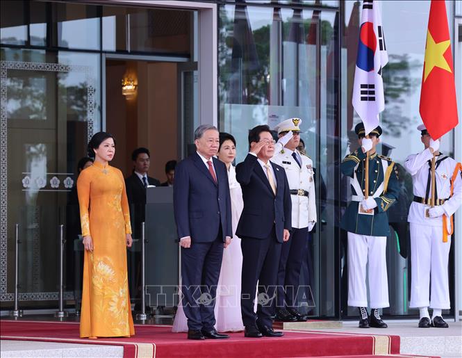 Tổng thống Hàn Quốc Lee Jae Myung và Phu nhân cùng Tổng Bí thư Tô Lâm và Phu nhân tại vị trí danh dự, nghe quân nhạc cử Quốc thiều hai nước. Ảnh: Thống Nhất - TTXVN