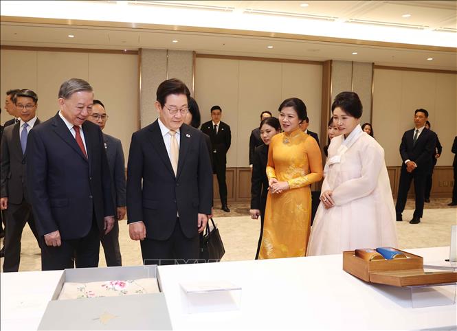 Tổng Bí thư Tô Lâm và Phu nhân giới thiệu tặng phẩm với Tổng thống Hàn Quốc Lee Jae Myung và Phu nhân. Ảnh: Thống Nhất - TTXVN