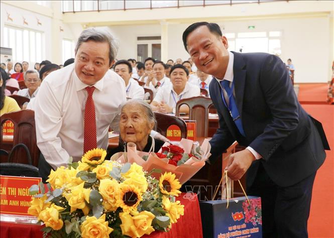 Ủy viên Ban Thường vụ Tỉnh ủy, Trưởng Ban Nội chính Tỉnh ủy Đồng Nai Nguyễn Minh Hợi và Bí thư Đảng ủy phường Chơn Thành Nguyễn Minh Bình tặng quà cho Mẹ Việt Nam Anh hùng Nguyễn Thị Ngừng. Ảnh: Nhật Bình – TTXVN