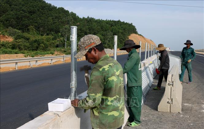 Nhà thầu triển khai lắp đặt lưới chống chói trên giải phân cách cứng. Ảnh: Quốc Khánh - TTXVN