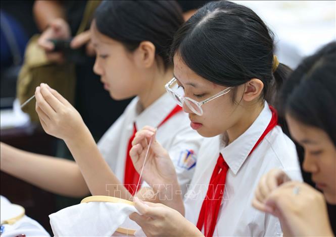 Học sinh trường THCS Trưng Vương hào hứng tham gia trải nghiệm học thêu cổ điển. Ảnh: Thanh Tùng - TTXVN