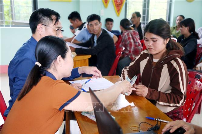 Người dân bản Hà Lẹc (xã Kim Ngân, tỉnh Quảng Trị) nhận tiền hỗ trợ giảm phát thải khí nhà kính và tiền nhận khoán, chăm sóc bảo vệ rừng. Ảnh: Tá Chuyên - TTXVN