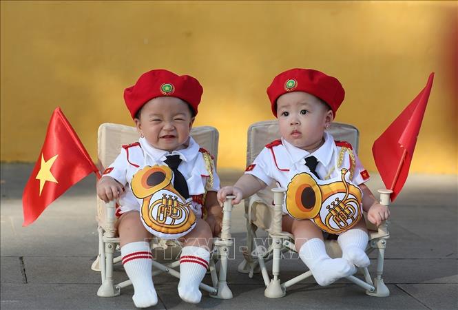 Các bạn nhỏ được gia đình lưu lại khoảnh khắc đẹp cùng với lá cờ Tổ quốc. Ảnh: Khánh Hòa - TTXVN 