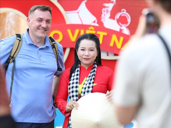 Du khách nước ngoài thích thú lưu lại khoảnh khắc với hình ảnh người phụ nữ Việt Nam mặc áo dài truyền thống. Ảnh: Khánh Hòa - TTXVN