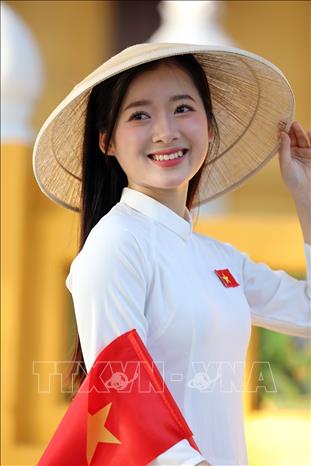 Thiếu nữ Việt Nam duyên dáng trong tà áo dài cùng lá cờ Tổ quốc. Ảnh: Khánh Hòa - TTXVN