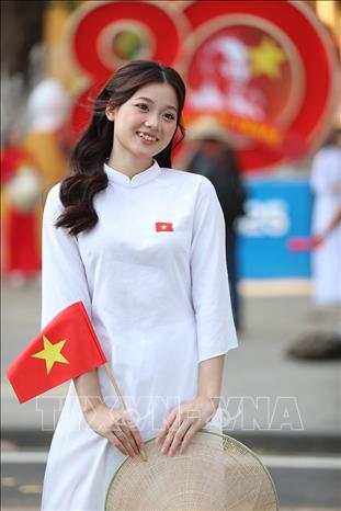 Thiếu nữ Việt Nam duyên dáng trong tà áo dài cùng lá cờ Tổ quốc. Ảnh: Khánh Hòa - TTXVN