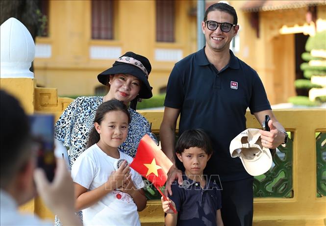 Du khách nước ngoài thích thú lưu lại những khoảnh khắc cùng lá cờ Việt Nam. Ảnh: Khánh Hòa - TTXVN 