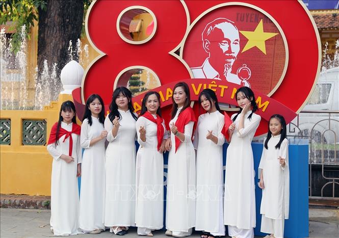 Đối với nhiều người dân, chụp ảnh cùng lá cờ Tổ quốc cũng là cách thể hiện tình yêu nước hướng đến ngày Đại lễ của dân tộc. Ảnh: Khánh Hòa - TTXVN 