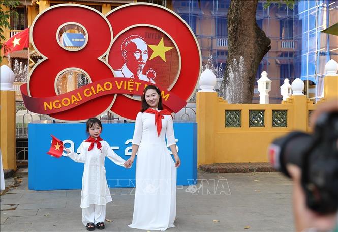 Đối với nhiều người dân, chụp ảnh cùng lá cờ Tổ quốc cũng là cách thể hiện tình yêu nước hướng đến ngày Đại lễ của dân tộc. Ảnh: Khánh Hòa - TTXVN 