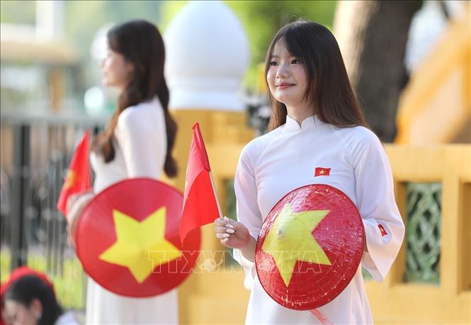 Đối với nhiều người dân, chụp ảnh cùng lá cờ Tổ quốc cũng là cách thể hiện tình yêu nước hướng đến ngày Đại lễ của dân tộc. Ảnh: Khánh Hòa - TTXVN 