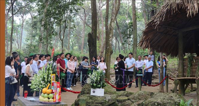 Du khách dâng hương và nghe thuyết minh tại lán Nà Nưa, Khu di tích Quốc gia đặc biệt Tân Trào, xã Tân Trào (Tuyên Quang). Ảnh: Hoàng Hải - TTXVN 