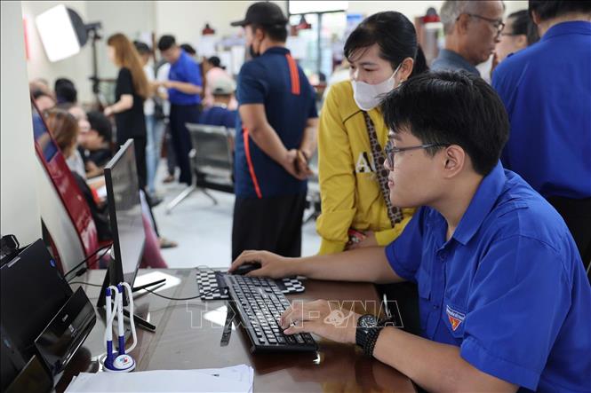 Tình nguyện viên tận tình hướng dẫn người dân nộp hồ sơ trực truyến tại Trung tâm Phục vụ Hành chính công phường Bà Rịa (TP. Hồ Chí Minh). Ảnh: Huỳnh Sơn - TTXVN 