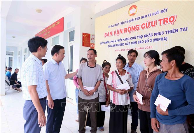 Bí thư Đảng ủy phường Tô Hiệu, ông Hà Trung Chiến và Bí thư Đảng ủy xã Huổi Một ông Đỗ Tuấn Đạt thăm hỏi, động viên, trao tiền hỗ trợ cho các hộ dân bị mất nhà hoàn toàn trong đợt mưa lũ vừa qua. Ảnh: Quang Quyết - TTXVN
