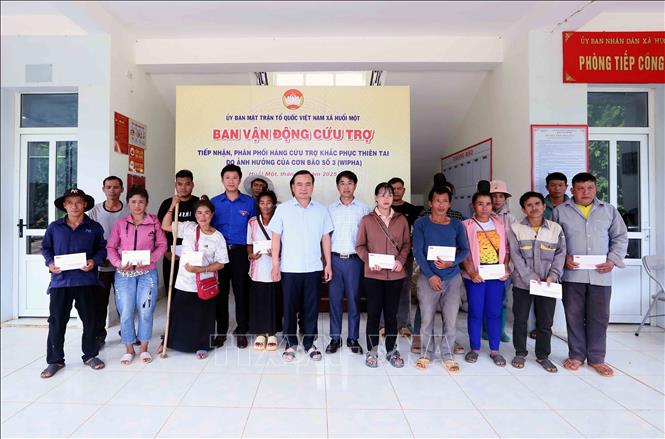 Bí thư Đảng ủy phường Tô Hiệu, ông Hà Trung Chiến và Bí thư Đảng ủy xã Huổi Một ông Đỗ Tuấn Đạt trao tiền hỗ trợ cho các hộ dân bị mất nhà hoàn toàn trong đợt mưa lũ vừa qua. Ảnh: Quang Quyết - TTXVN