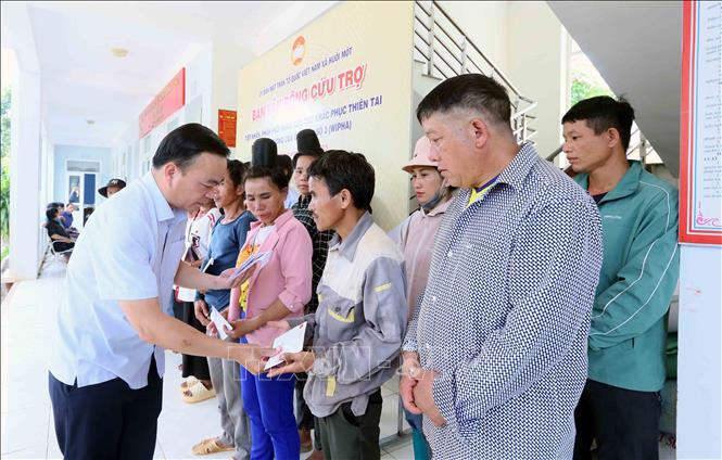 Bí thư Đảng ủy phường Tô Hiệu, tỉnh Sơn La ông Hà Trung Chiến trao tiền hỗ trợ cho các hộ dân xã Huổi Một bị mất nhà hoàn toàn trong đợt mưa lũ vừa qua. Ảnh: Quang Quyết - TTXVN