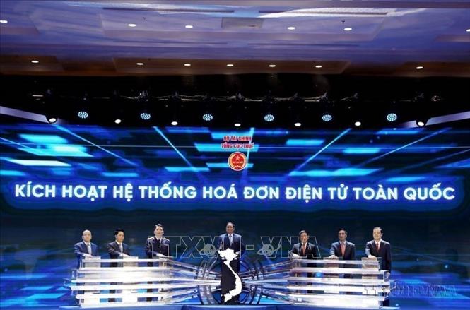 Thủ tướng Phạm Minh Chính, Bộ trưởng Bộ Tài chính Hồ Đức Phớc và các đại biểu thực hiện nghi thức ấn nút kích hoạt Hệ thống hóa đơn điện tử toàn quốc. Ảnh: Phạm Hậu - TTXVN