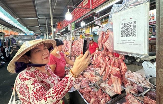  Thay vì sử dụng tiền mặt, nhiều người dân ở Thành phố Hồ Chí Minh đã sử dụng điện thoại có kết nối internet quét mã QR khi đi chợ. Mô hình chợ trực tuyến, chợ 4.0 đang ngày càng phổ biến tại Thành phố Hồ Chí Minh. Ảnh: Văn Phúc - TTXVN