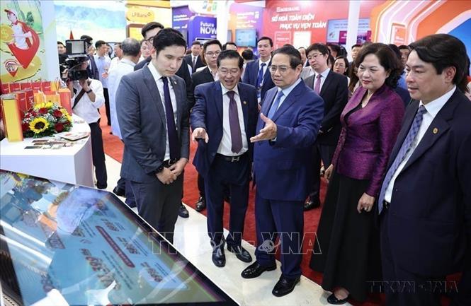 Thủ tướng Phạm Minh Chính tham quan trưng bày sản phẩm dịch vụ, ứng dụng chuyển đổi số trong hoạt động ngân hàng (Hà Nội, 29/5/2025). Ảnh: Dương Giang-TTXVN