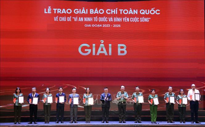 Đồng chí Lê Quốc Minh, Uỷ viên Trung ương Đảng, Phó Trưởng Ban Tuyên giáo và Dân vận Trung ương, Tổng Biên tập Báo Nhân Dân, Chủ tịch Hội Nhà báo Việt Nam và Thượng tướng Trần Quốc Tỏ, Uỷ viên Trung ương Đảng, Thứ trưởng Bộ Công an trao giải Nhì cho các tác giả, đại diện nhóm tác giả. Ảnh: Tuấn Anh - TTXVN