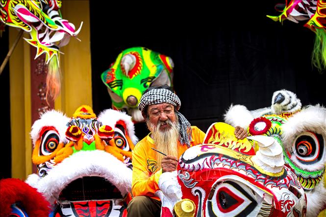 Từ khung tre mộc mạc, qua bàn tay nghệ nhân, đầu lân trở thành tác phẩm nghệ thuật. Ảnh: Giang Phương - TTXVN