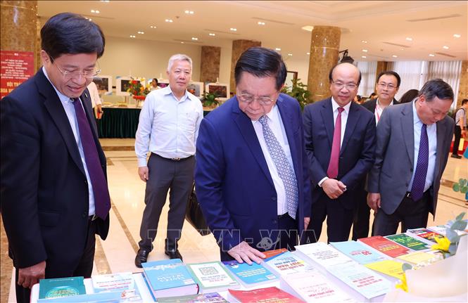Trưởng Ban Tuyên giáo và Dân vận Trung ương Nguyễn Trọng Nghĩa với các đại biểu tham quan trưng bày sách tại hội thảo. Ảnh:Văn Điệp - TTXVN