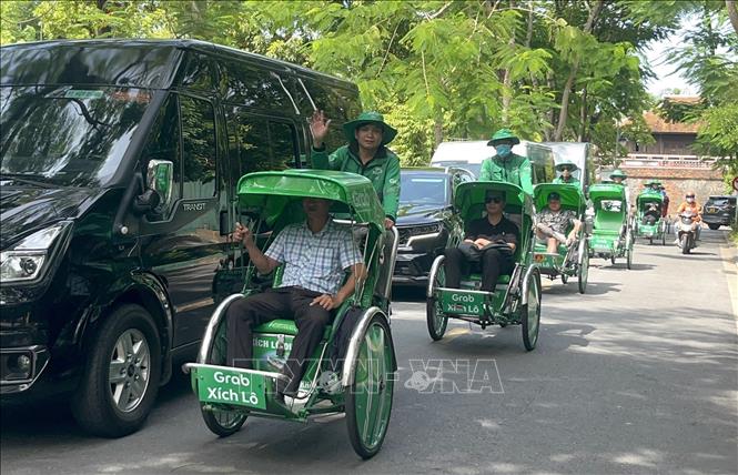 Người dân trải nghiệm mô hình dịch vụ Grab Xích lô tại Huế. Ảnh: Văn Dũng-TTXVN