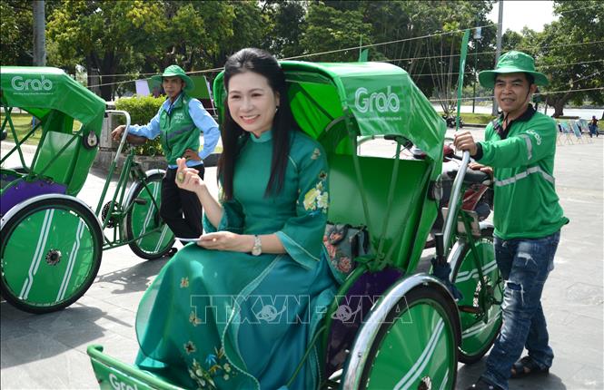 Người dân trải nghiệm mô hình dịch vụ Grab Xích lô tại Huế. Ảnh: Văn Dũng-TTXVN