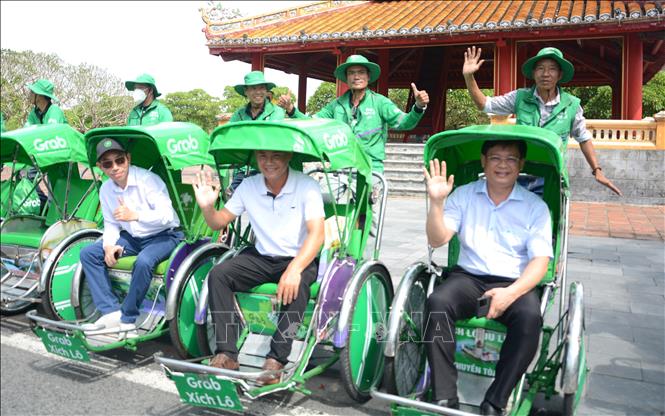 Người dân trải nghiệm mô hình dịch vụ Grab Xích lô tại Huế. Ảnh: Văn Dũng-TTXVN