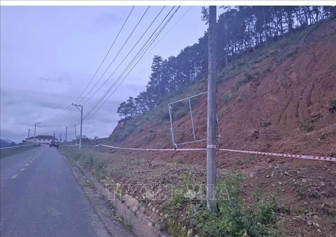 Lực lượng chức năng chăng dây, cắm biển cảnh báo tại khu vực đồi thông gần hồ thuỷ điện Đạ Dâng (thuộc thôn Păng Tiêng, xã Lát, huyện Lạc Dương trước đây). Ảnh: TTXVN phát 