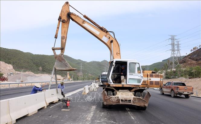 Lắp đặt dải phân cách cứng giữa hai làn đường. Ảnh: Quốc Khánh - TTXVN