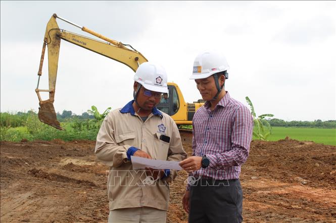 Các kỹ sư, công nhân đơn vị thi công bàn các giải pháp đẩy nhanh tiến độ san lấp mặt bằng. Ảnh: Nguyễn Thắng - TTXVN