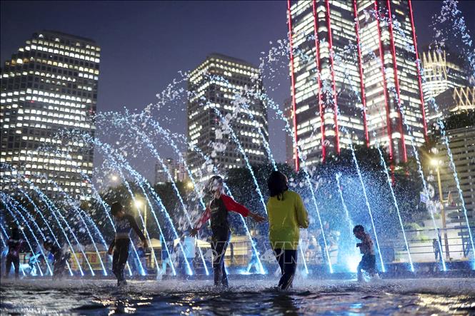 Các em nhỏ chơi đùa bên đài phun nước để tránh nóng, tại thủ đô Seoul, Hàn Quốc. Ảnh: Yonhap/TTXVN