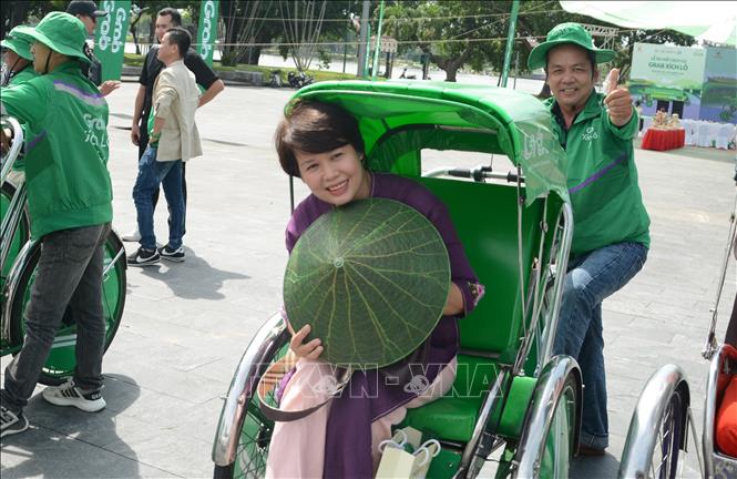 A local enjoys the newly launched “Grab Cyclo”. VNA Photo: Văn Dũng
