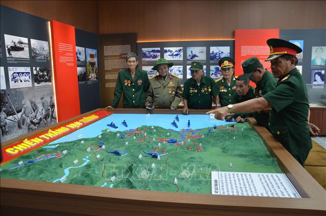 Các cựu chiến binh ôn lại kỷ niệm qua bản đồ trận Vạn Tường. Ảnh: Đinh Hương - TTXVN
