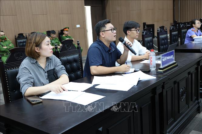 Phiên dịch cho các bị cáo người nước ngoài dịch câu hỏi của Hội đồng xét xử. Ảnh: Vũ Quang – TTXVN