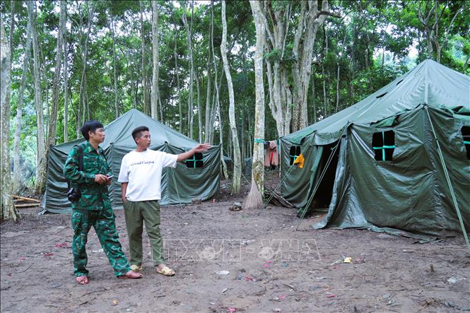 Bí thư Chi bộ bản Phá Mựt (xã Nhôn Mai, tỉnh Nghệ An) trao đổi với lực lượng biên phòng về vị trí lắp đặt đèn năng lượng mặt trời cho dân bản. Ảnh: Xuân Tiến - TTXVN 