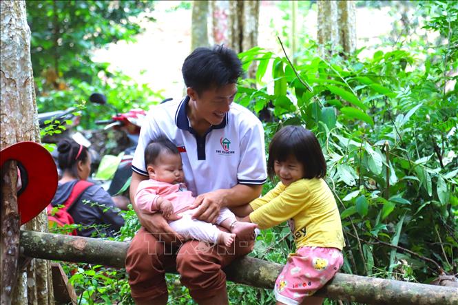 Niềm hạnh phúc của ba bố con người Mông bản Phá Mựt trong khu nhà bạt. Ảnh: Xuân Tiến - TTXVN 