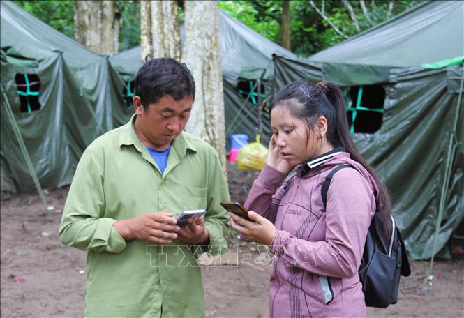 Người dân chia sẻ, kết nối sóng 3G cho nhau để phục vụ nhu cầu nắm bắt thông tin, giải trí trên điện thoại. Ảnh: Xuân Tiến - TTXVN 

