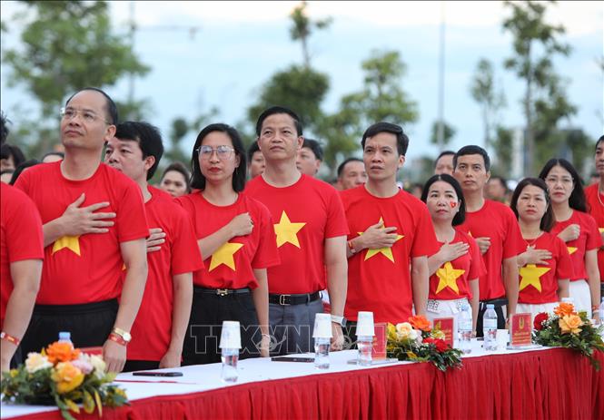 Các đại biểu thể hiện tình yêu đất nước trong lễ chào cờ. Ảnh: Danh Lam -TTXVN 