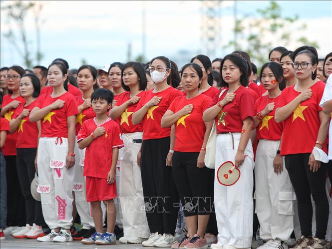 Các đại biểu thể hiện tình yêu đất nước trong lễ chào cờ. Ảnh: Danh Lam -TTXVN 
