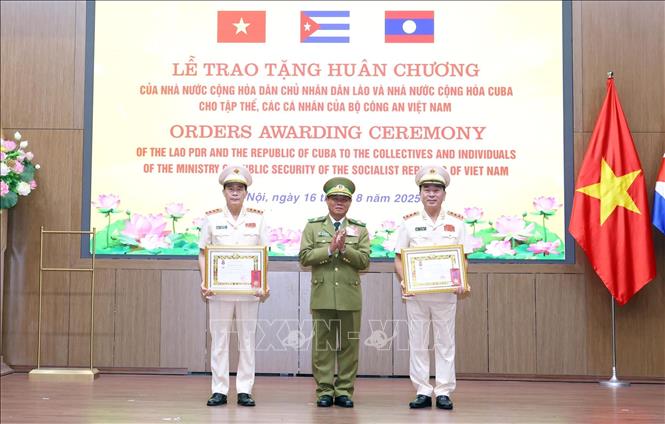 Phó Thủ tướng Chính phủ, Bộ trưởng Bộ Công an Lào Vilay Lakhamphong trao tặng Huân chương Tự do hạng Nhì của Nhà nước Lào cho Thượng tướng Trần Quốc Tỏ, Thứ trưởng Bộ Công an Việt Nam (bên phải) và Thượng tướng Lê Quốc Hùng, Thứ trưởng Bộ Công an Việt Nam. Ảnh: Phạm Kiên - TTXVN
