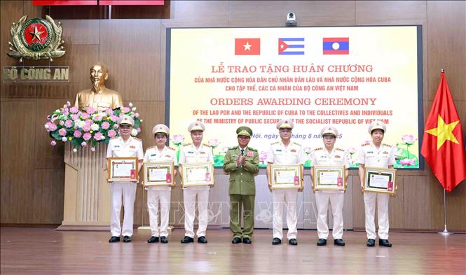Phó Thủ tướng Chính phủ, Bộ trưởng Bộ Công an Lào Vilay Lakhamphong trao tặng Huân chương Tự do hạng Ba của Nhà nước Lào cho các đồng chí Thứ trưởng Bộ Công an Việt Nam và Huân chương Lao động hạng Nhất cho Thượng tướng Tô Ân Xô, Trợ lý Tổng Bí thư. Ảnh: Phạm Kiên - TTXVN