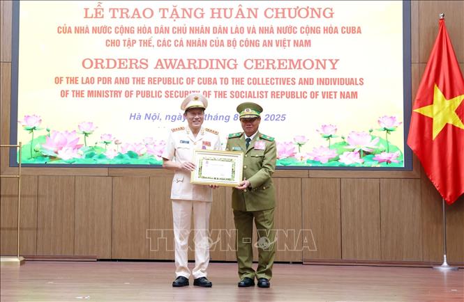 Phó Thủ tướng Chính phủ, Bộ trưởng Bộ Công an Lào Vilay Lakhamphong trao tặng Huân chương Tự do hạng Nhất của Nhà nước Lào cho Đại tướng Lương Tam Quang, Bộ trưởng Bộ Công an Việt Nam. Ảnh: Phạm Kiên - TTXVN