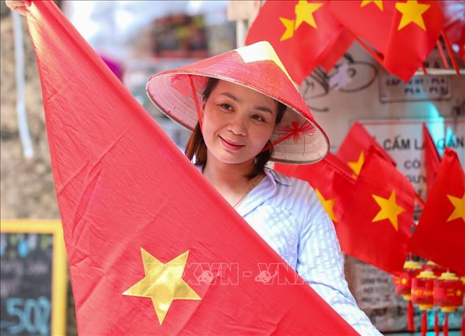 Người dân lưu lại khoảnh khắc với hình ảnh cờ Tổ quốc tại phố Hàng Mã, phường Hoàn Kiếm. Ảnh: Khánh Hoà - TTXVN