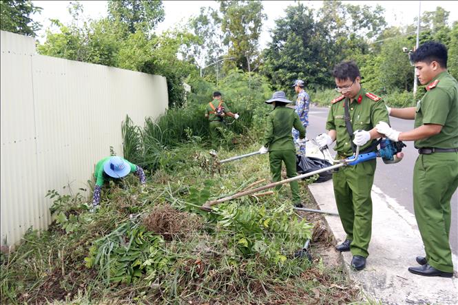 Lực lượng công an ra quân thu gom rác thải, phát quang bụi rậm khu vực tuyến đường ven biển phường Tiến Thành, tỉnh Lâm Đồng. Ảnh: Nguyễn Thanh - TTXVN