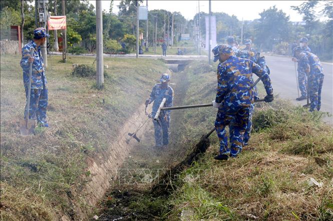 Chiến sĩ Lữ đoàn 681 (Vùng 2 Hải quân) ra quân thu gom rác thải, phát quang bụi rậm, khơi thông công rãnh khu vực tuyến đường ven biển phường Tiến Thành, tỉnh Lâm Đồng. Ảnh: Nguyễn Thanh - TTXVN