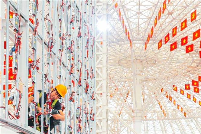 A worker installs LED screen for the exhibition. VNA Photo