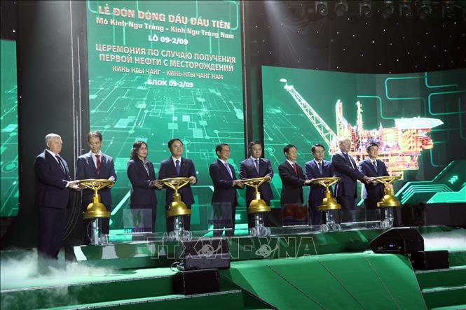 Các đại biểu thực hiện nghi thức mở van đón dòng dầu đầu tiên. Ảnh: Đoàn Mạnh Dương-TTXVN