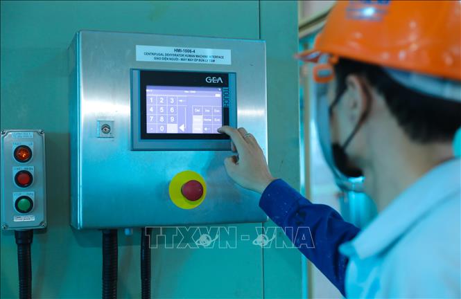 Các kỹ sư đang vận hành hệ thống máy nén bùn trọng lực để vắt khô bùn trước khi vận chuyển đến bãi chôn lấp Yên Sở. Ảnh: Thành Phương – TTXVN